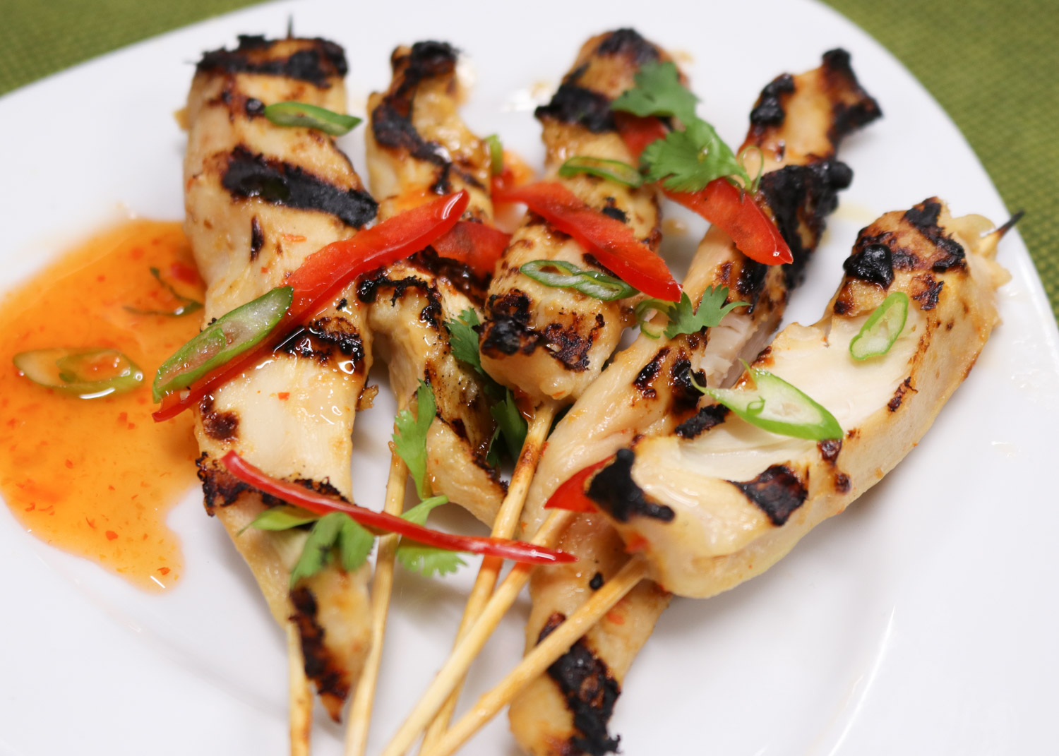 Thai sweet chili sauce marinated chicken skewers with cilantro, scallion, and chili