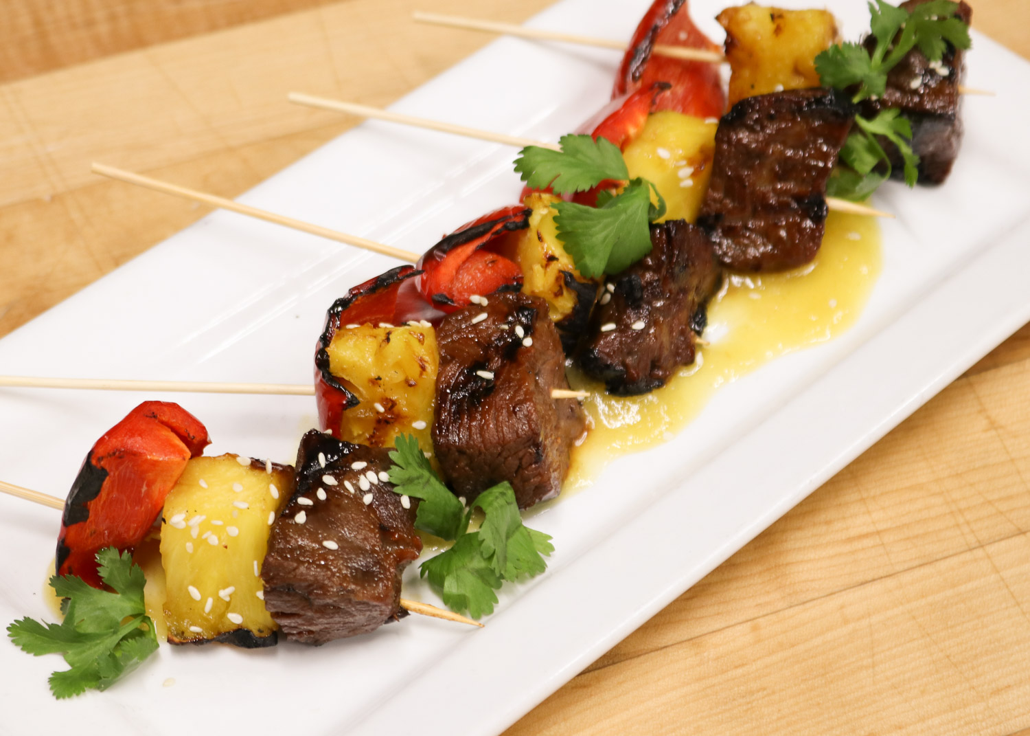 Steak skewers with soy, ginger, citrus, caramelized pineapple, red pepper, sesame, and habanero mango glaze